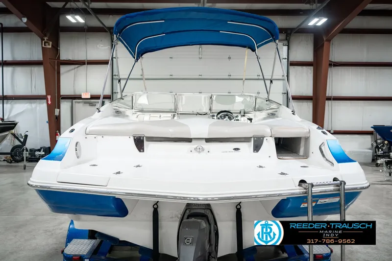 Slide: The Image of 2007 Larson LXi 228 Wakeboard Edition boat with blue canopy in indoor showroom. - 9