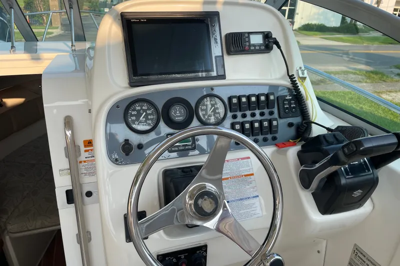 Slide: The Image of 2007 Robalo R265 Walkaround boat dashboard with steering wheel and navigation controls. - 12