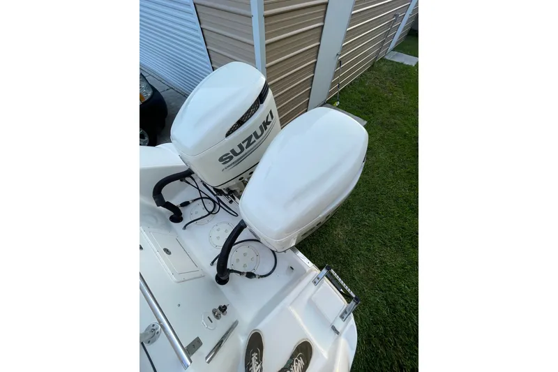 Slide: The Image of 2007 Robalo R265 Walkaround with dual Suzuki outboard motors, parked on grass. - 9