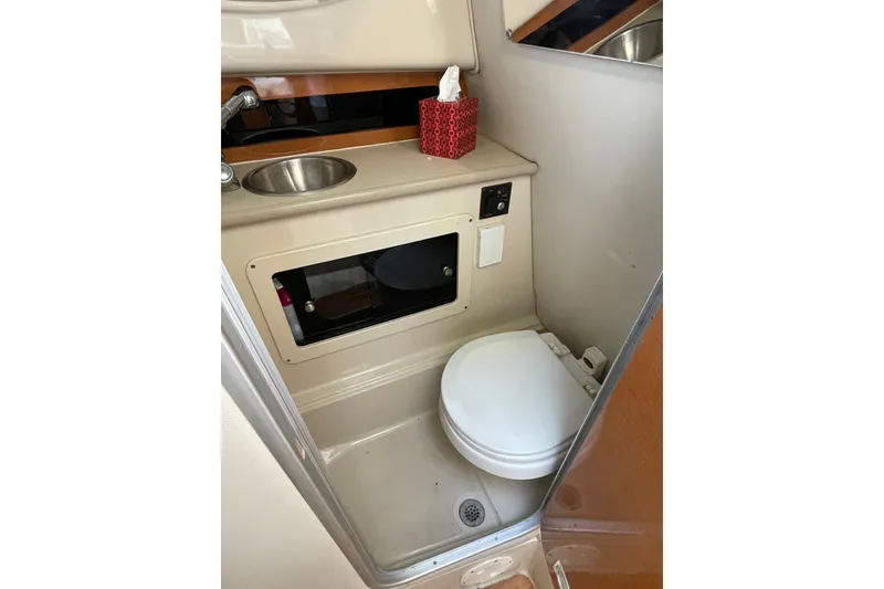 Slide: The Image of 2007 Robalo R265 Walkaround boat bathroom with sink, toilet, and storage cabinet. - 29