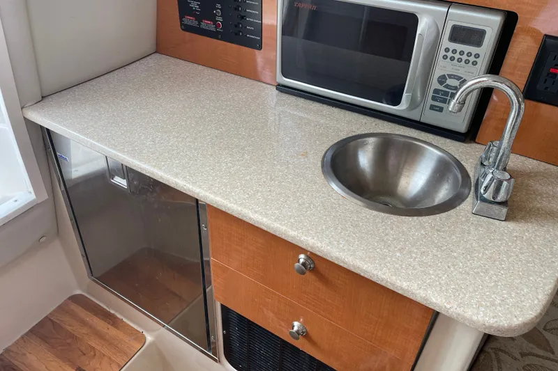 Slide: The Image of 2007 Robalo R265 Walkaround interior with sink, microwave, and countertop. - 28