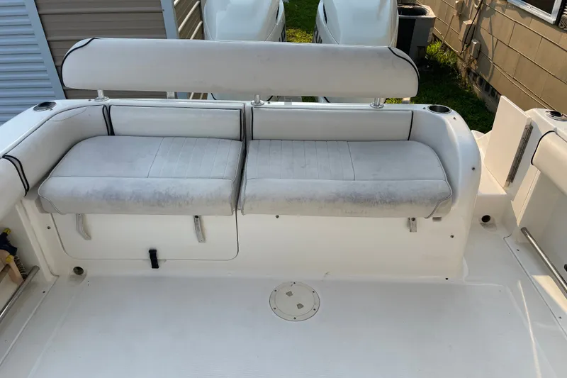 Slide: The Image of 2007 Robalo R265 Walkaround boat seating area with white cushioned bench. - 13