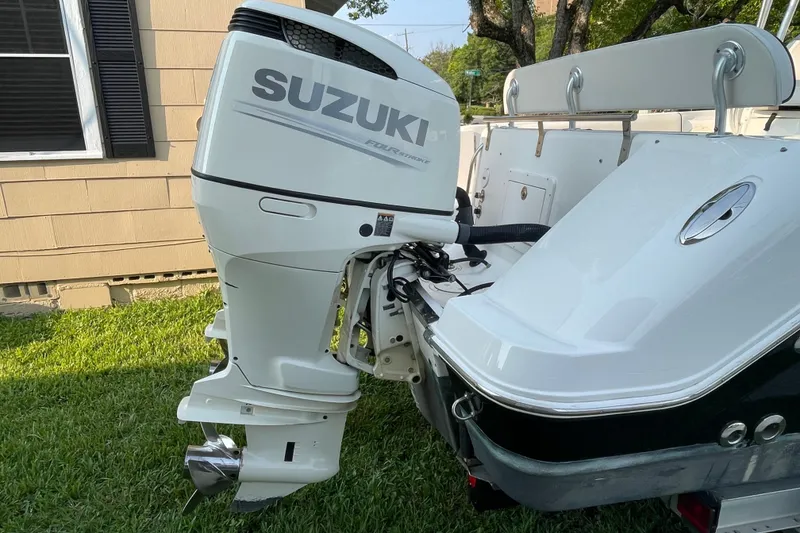 Slide: The Image of 2007 Robalo R265 Walkaround with Suzuki outboard motor, parked on grass. - 7