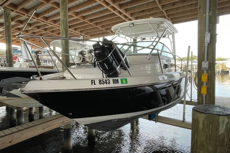 Slide: The Image of 2007 Robalo R265 Walkaround boat docked in a covered marina. - 4