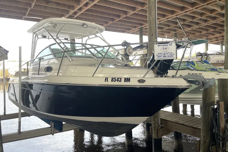 Slide: The Image of 2007 Robalo R265 Walkaround boat on lift in marina, side view. - 3