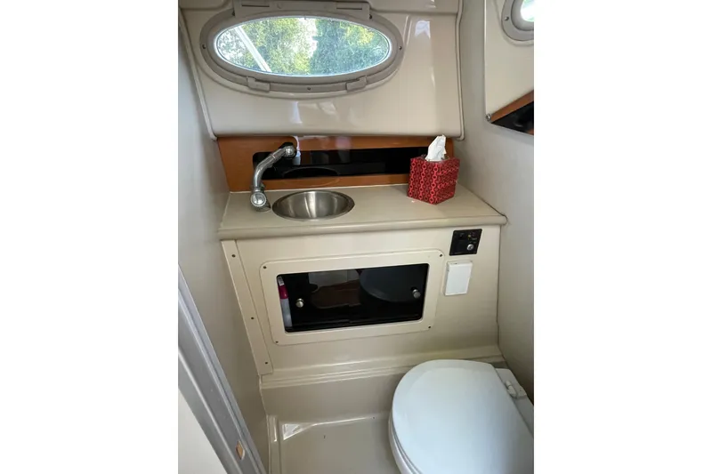 Slide: The Image of 2007 Robalo R265 Walkaround boat bathroom with sink, toilet, and storage compartment. - 30