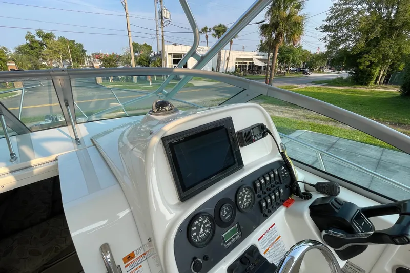 Slide: The Image of 2007 Robalo R265 Walkaround boat dashboard with navigation instruments and steering wheel. - 16