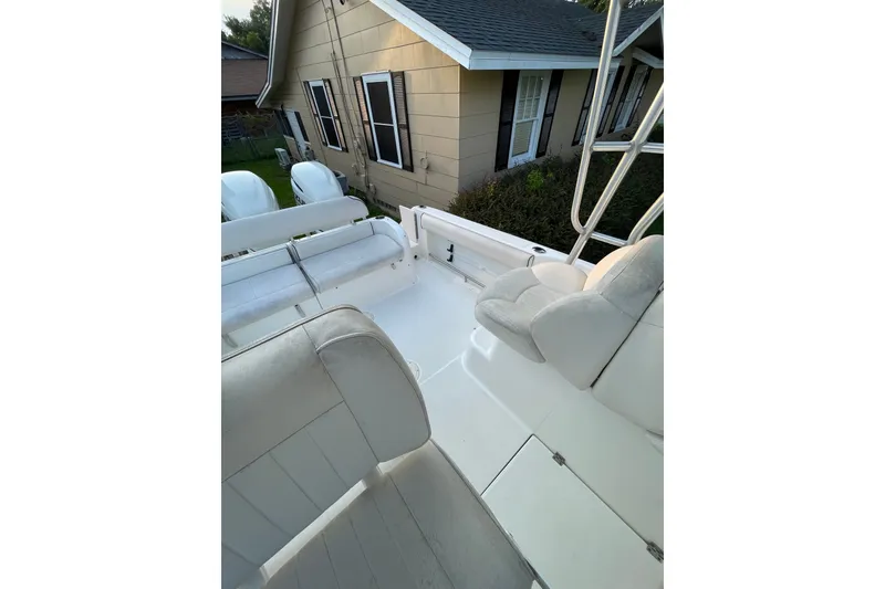 Slide: The Image of 2007 Robalo R265 Walkaround boat interior with white seating, near a house. - 22