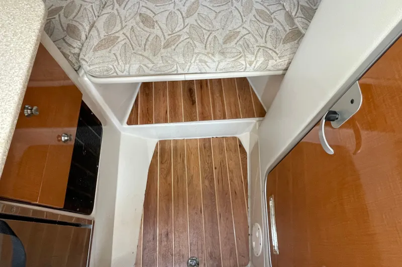Slide: The Image of 2007 Robalo R265 Walkaround cabin interior with wood flooring and patterned upholstery. - 26