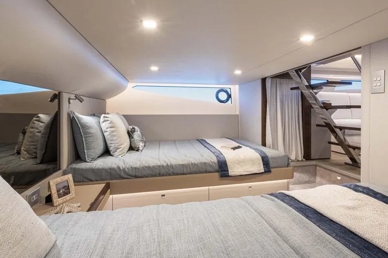 Slide: The Image of Manufacturer Provided Image: Luxurious cabin interior of 2026 Riviera 4300 Sport Express yacht with modern bedding and decor. - 13