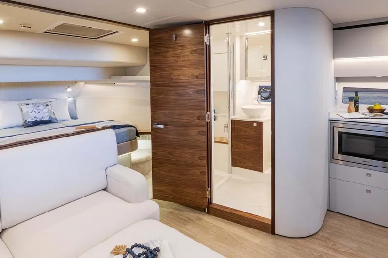 Slide: The Image of Manufacturer Provided Image: Luxurious interior of 2026 Riviera 4300 Sport Express yacht with bedroom, bathroom, and kitchenette. - 11