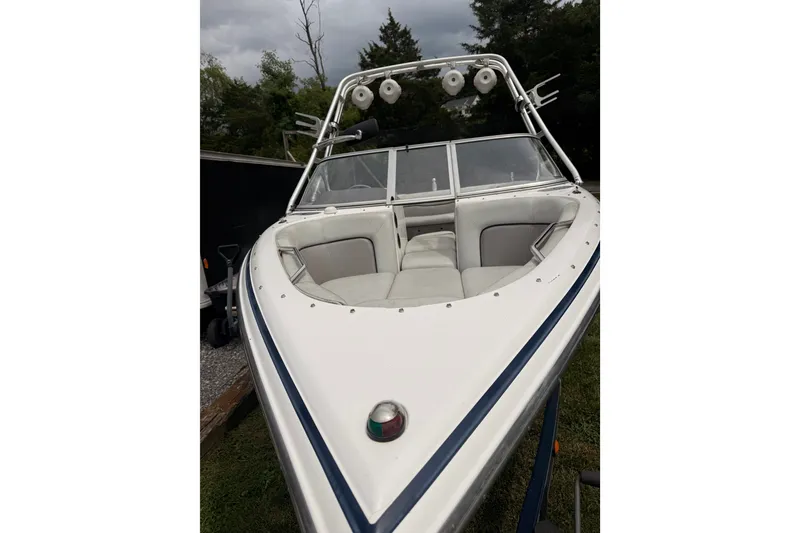 Slide: The Image of 2004 Supra Launch SSV boat with white seating and tower, parked outdoors. - 4