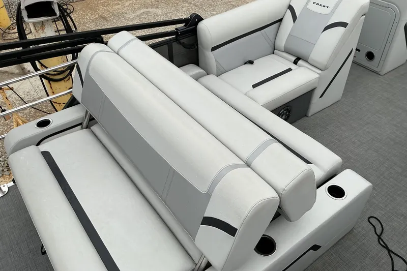 Slide: The Image of 2023 Crest Classic DLX 220 boat interior with plush gray seating and cup holders. - 9