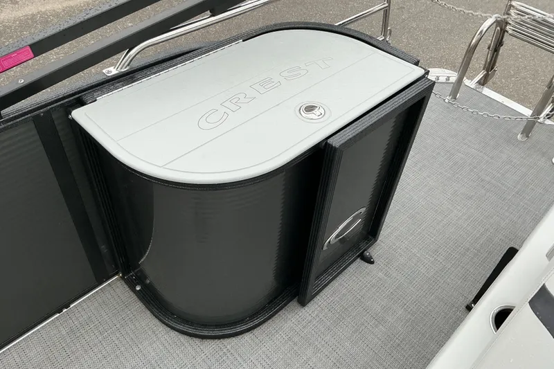 Slide: The Image of 2023 Crest Classic DLX 220 boat storage compartment with sleek black and gray design. - 12