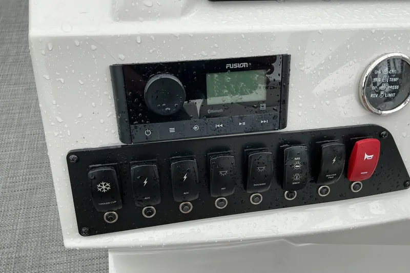 Slide: The Image of Control panel of 2023 Crest Classic DLX 220 boat with switches and audio system. - 14