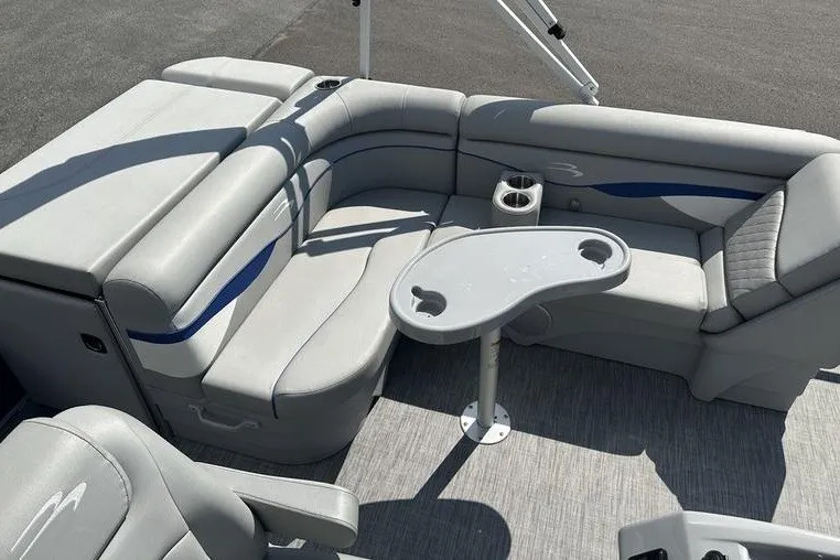 Slide: The Image of 2022 Bennington 2286 boat interior with gray seating and a central table. - 17