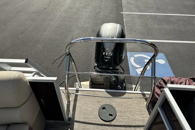 Slide: The Image of Bennington 2286 pontoon boat with Yamaha 115 engine, parked on asphalt. - 16