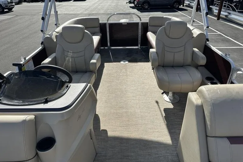 Slide: The Image of 2022 Bennington 2286 pontoon boat interior with beige seating and steering console. - 10