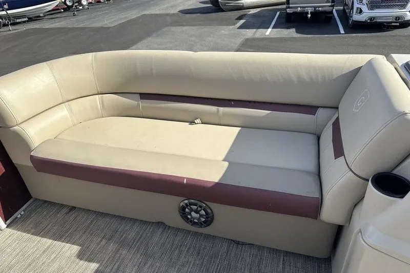 Slide: The Image of 2022 Bennington 2286 boat interior with beige and maroon seating, cup holder, and speaker. - 17