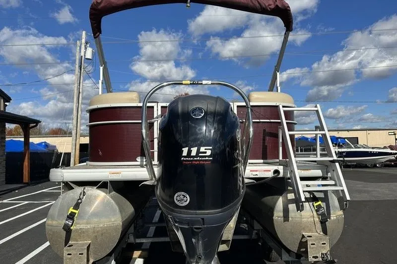 Slide: The Image of 2022 Bennington 2286 pontoon boat with 115 horsepower engine, parked outdoors under blue sky. - 14