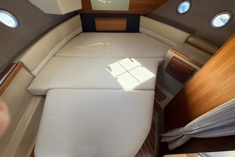 Slide: The Image of 2020 Ranger Tugs R-29 S cabin interior with cozy bed and porthole windows. - 19