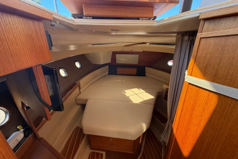Slide: The Image of 2020 Ranger Tugs R-29 S interior cabin with cozy bed and wooden accents. - 18