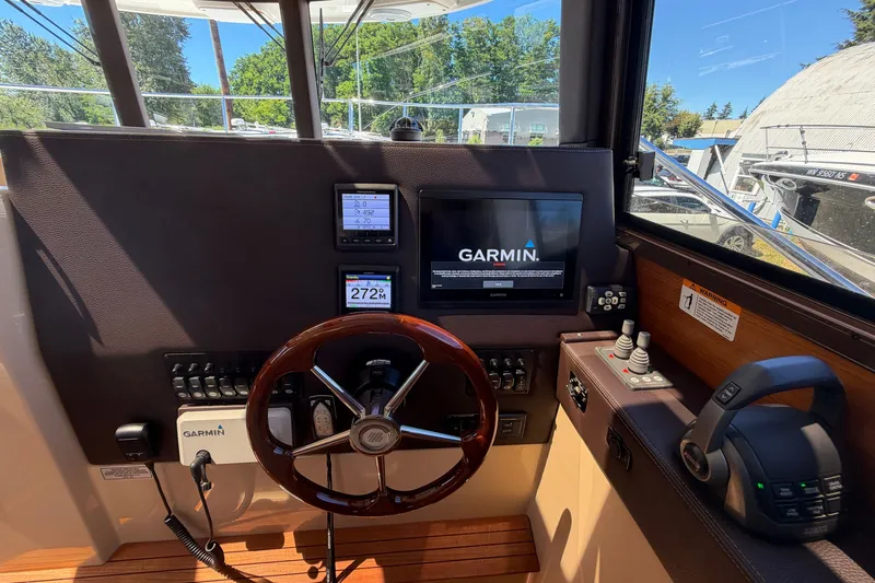 Slide: The Image of 2020 Ranger Tugs R-29 S helm with Garmin navigation system and wooden steering wheel. - 16