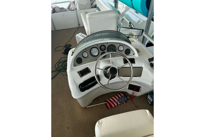 Slide: The Image of Steering console of a 2001 Landau DX 24 boat with gauges and American flag. - 5