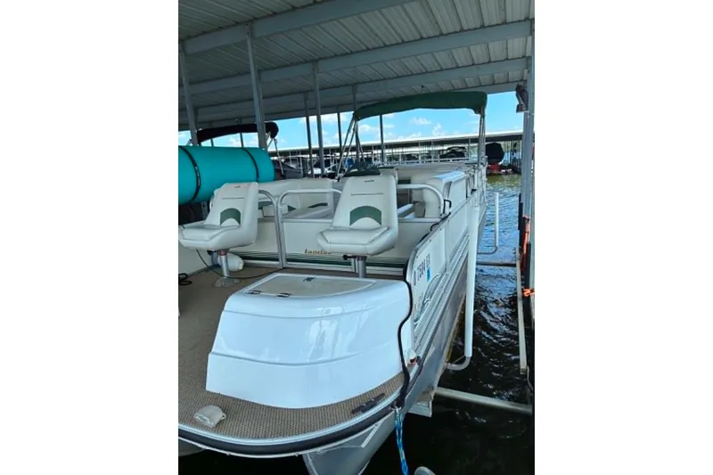 The Image of 2001 Landau DX 24 pontoon boat docked under a covered marina. - 0