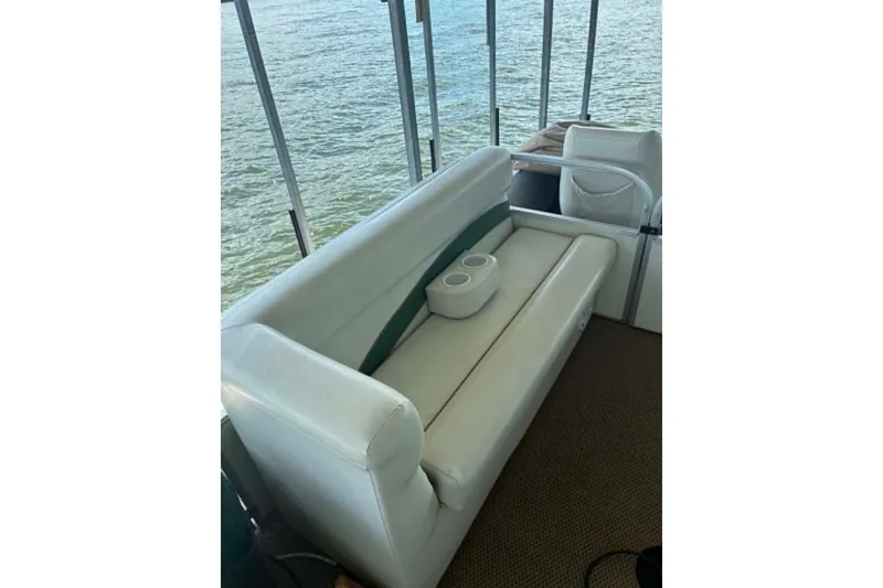 Slide: The Image of White seating area on a 2001 Landau DX 24 boat overlooking water. - 10