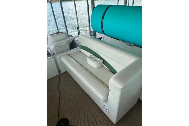 Slide: The Image of White and green boat seat on 2001 Landau DX 24, with cup holders, near water. - 4