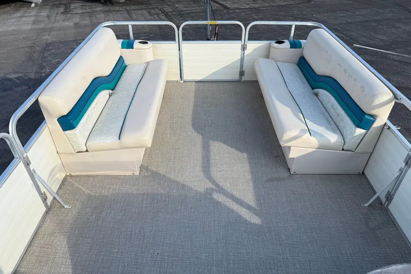 Slide: The Image of 1998 Lowe Family 245 pontoon boat interior with white and teal seating. - 21