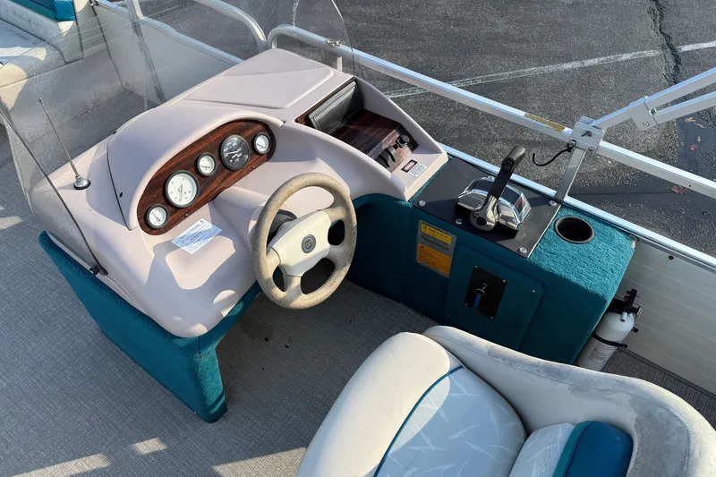 Slide: The Image of 1998 Lowe Family 245 boat dashboard with steering wheel and control panel. - 20