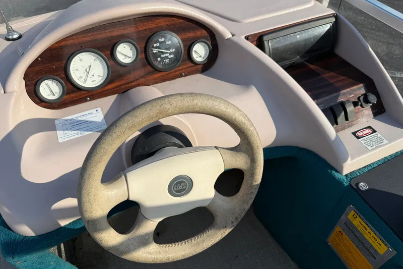 Slide: The Image of Steering console of a 1998 Lowe Family 245 boat with gauges and controls. - 19
