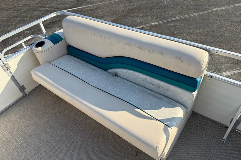 Slide: The Image of 1998 Lowe Family 245 boat seat with teal accents and cup holder on deck. - 9