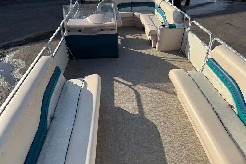 Slide: The Image of 1998 Lowe Family 245 pontoon boat interior with beige and teal seating. - 12