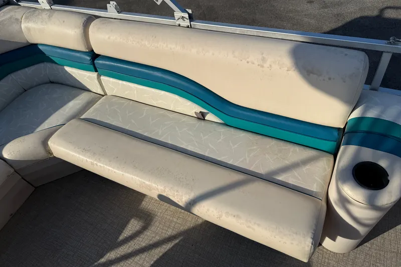 Slide: The Image of 1998 Lowe Family 245 boat seating with teal accents and cup holder. - 15