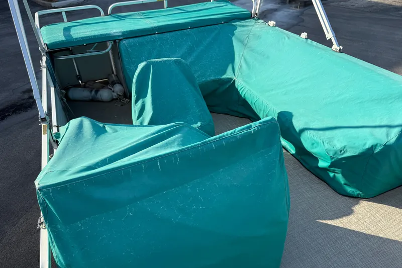 Slide: The Image of 1998 Lowe Family 245 boat interior with teal protective covers. - 25