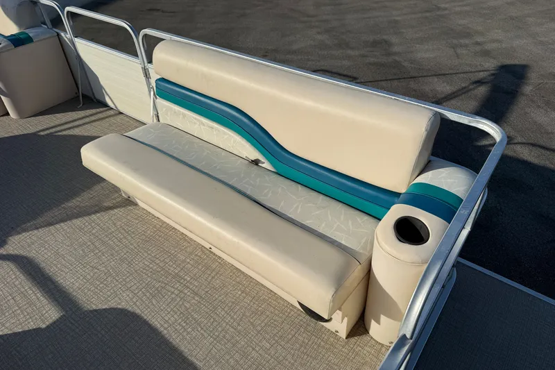 Slide: The Image of 1998 Lowe Family 245 boat seating with teal accents and cup holder. - 10