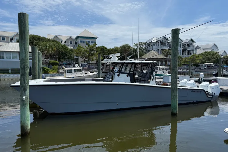 The Image of 2024 Freeman 38 boat docked in a marina with residential buildings in the background. - 0