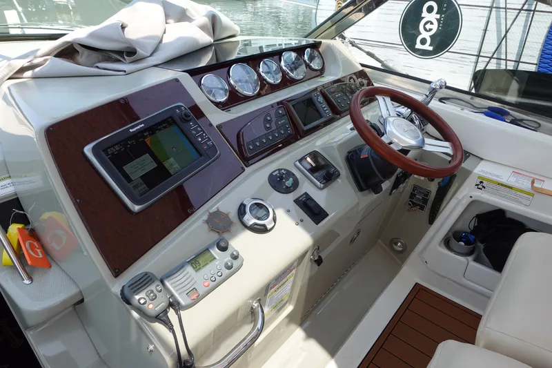 Slide: The Image of Helm of 2013 Sea Ray Sundancer 370 with navigation controls and wooden steering wheel. - 9