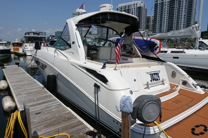 Slide: The Image of 2013 Sea Ray Sundancer 370 docked at marina, featuring sleek design and American flag. - 1