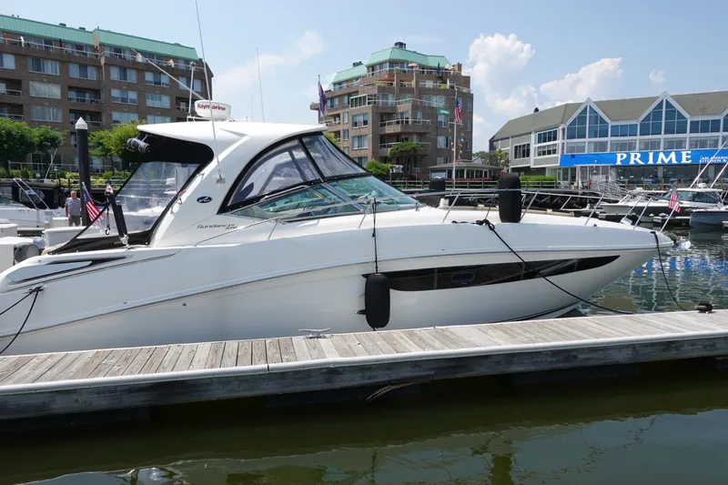 Slide: The Image of 2013 Sea Ray Sundancer 370 docked at a marina with waterfront buildings in the background. - 3