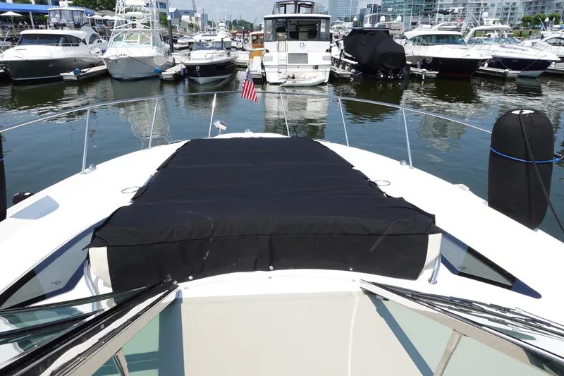 Slide: The Image of 2013 Sea Ray Sundancer 370 docked in a marina, featuring a covered bow area. - 7