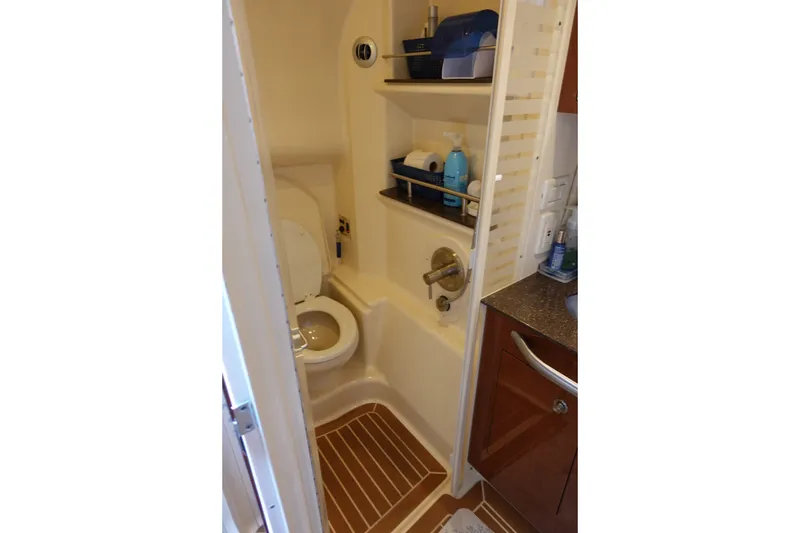 Slide: The Image of Bathroom interior of 2013 Sea Ray Sundancer 370 yacht, featuring toilet and storage shelves. - 32