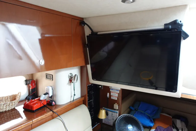 Slide: The Image of Interior of 2013 Sea Ray Sundancer 370 with mounted TV and wooden cabinetry. - 26