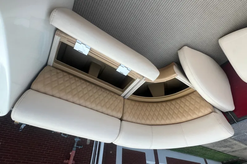 Slide: The Image of 2020 Lexington 521 boat interior with beige quilted seating and storage compartments. - 13