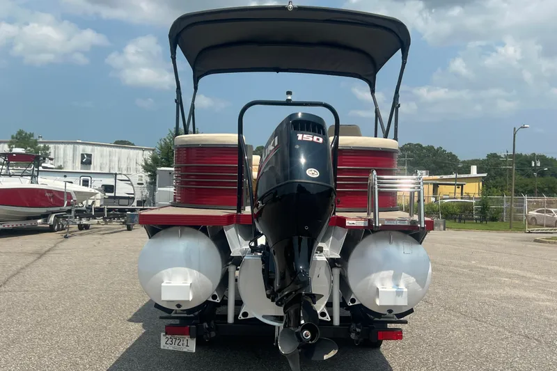Slide: The Image of 2020 Lexington 521 pontoon boat with 150 HP engine, parked outdoors under a cloudy sky. - 30
