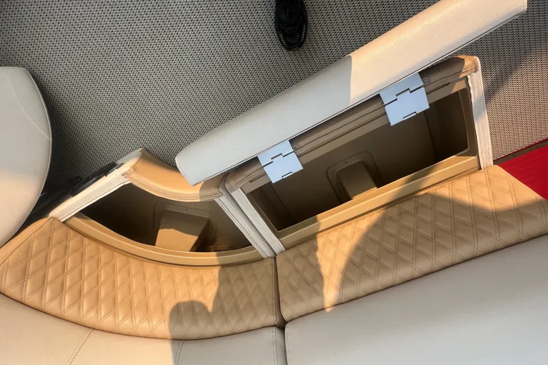Slide: The Image of Open storage compartments in a 2020 Lexington 521 boat with beige quilted seats. - 12