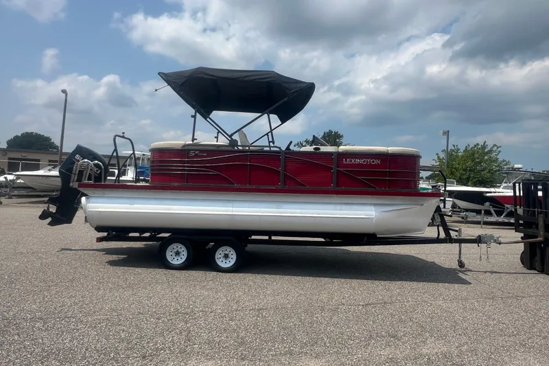 Slide: The Image of 2020 Lexington 521 pontoon boat with canopy on a trailer under cloudy sky. - 27